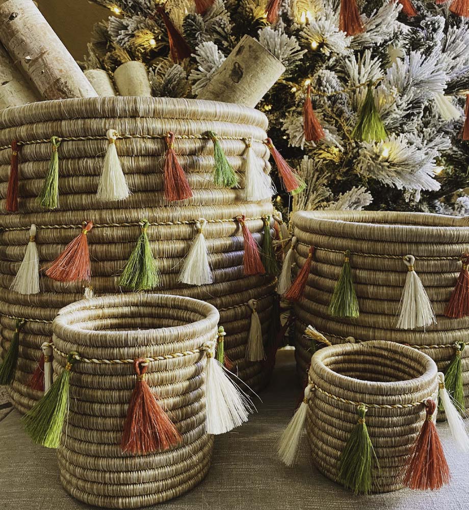 Four Baskets in front of a christmas tree with green, white, and red garland wrapped around them