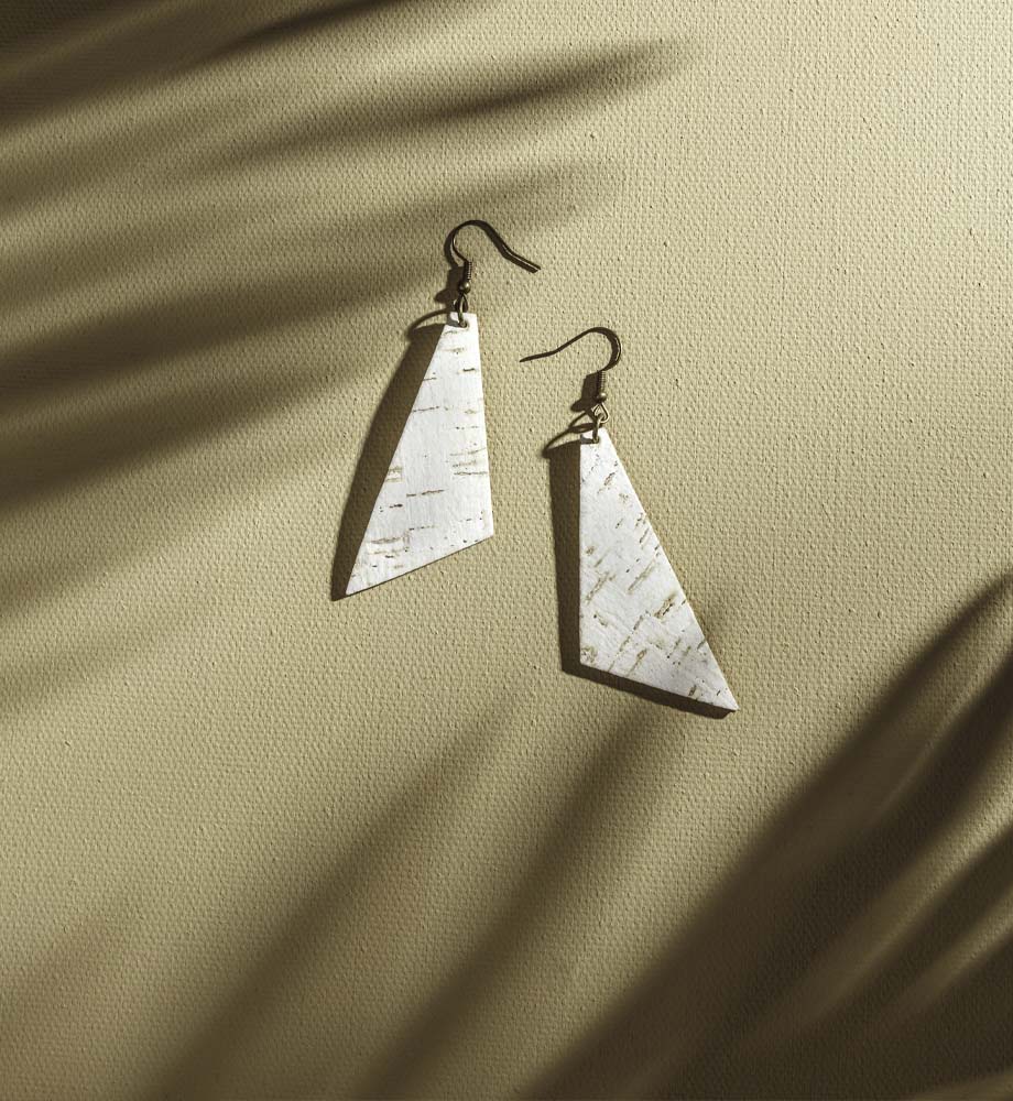 earrings with white triangles on a tan background