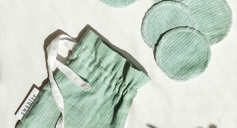 Green reusable fabric facial pads with matching green drawstring bag