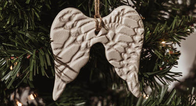 White angel wing ornament in a green Christmas tree