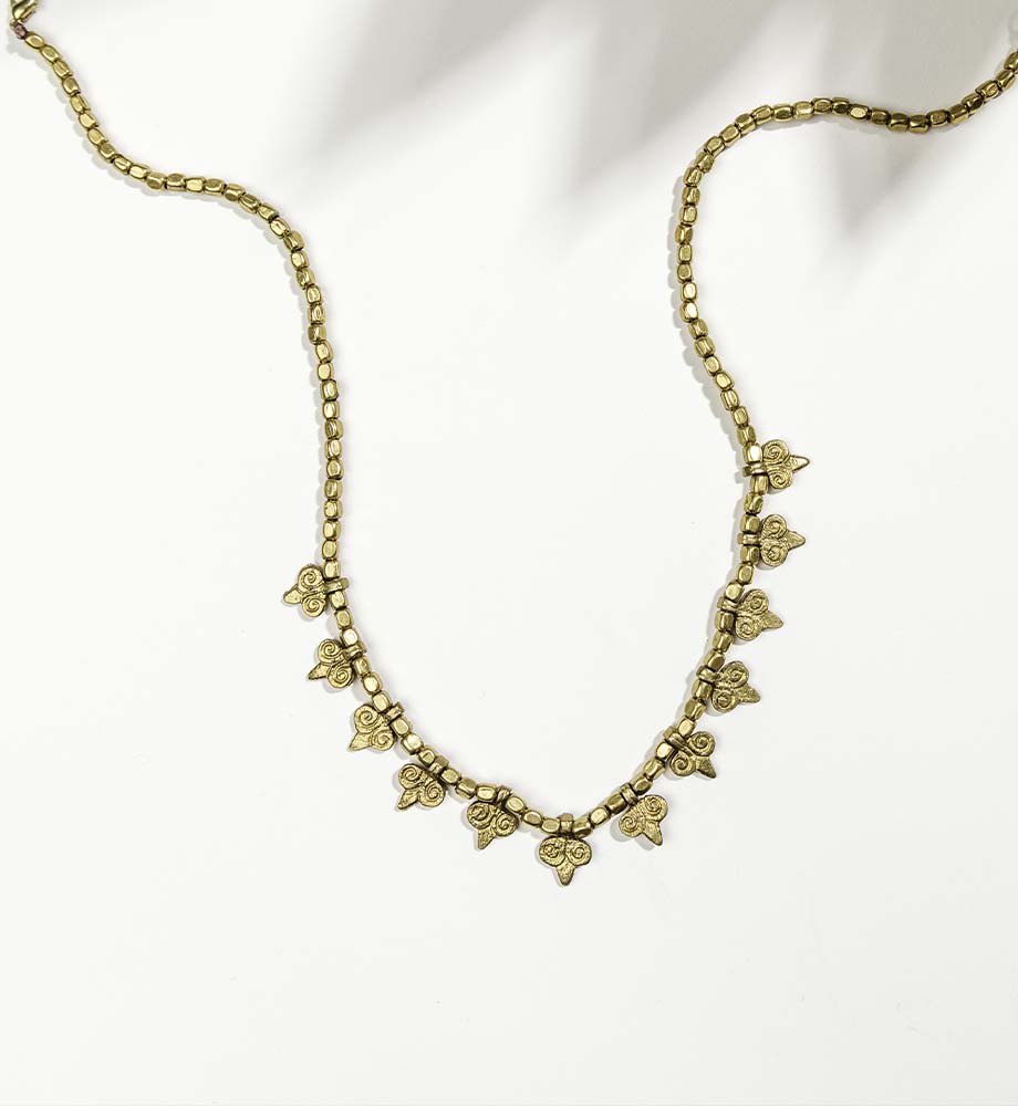 Gold necklace laying on a white background 