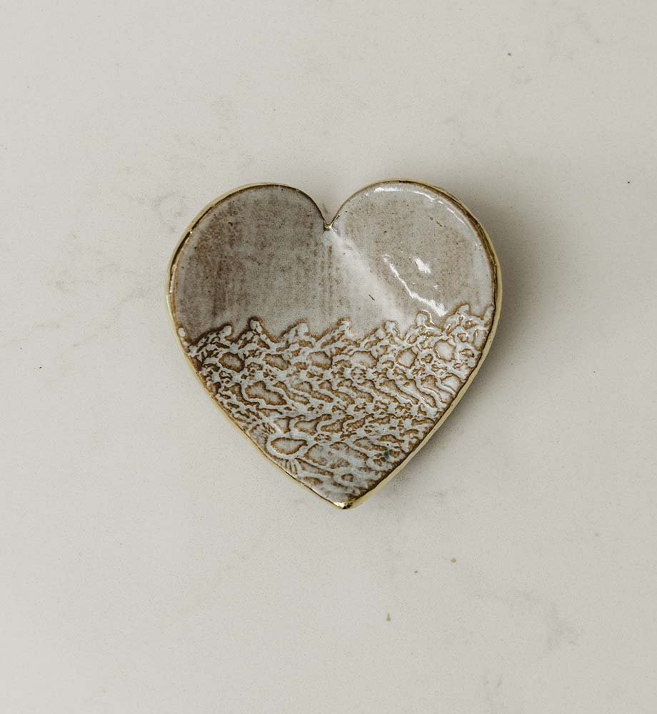 White and gold ring dish made of clay in a shape of a heart