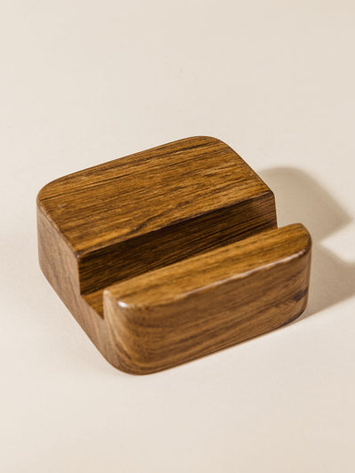 Wooden cell phone stand on cream background.