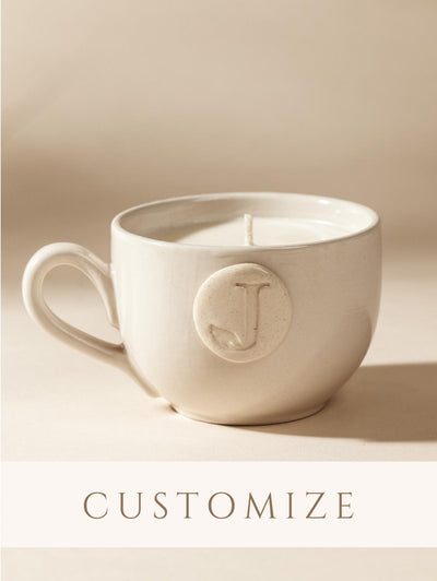Customizable white mug candle on a cream background. 