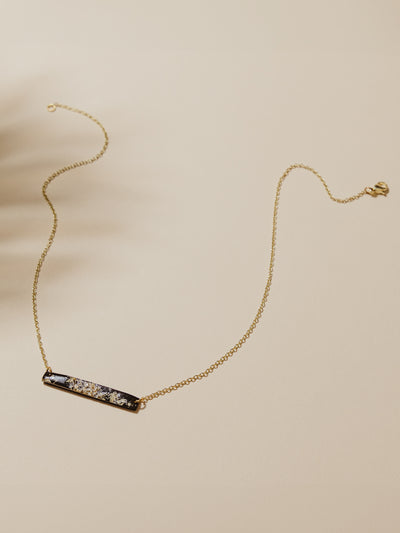Black necklace with gold chain on a table