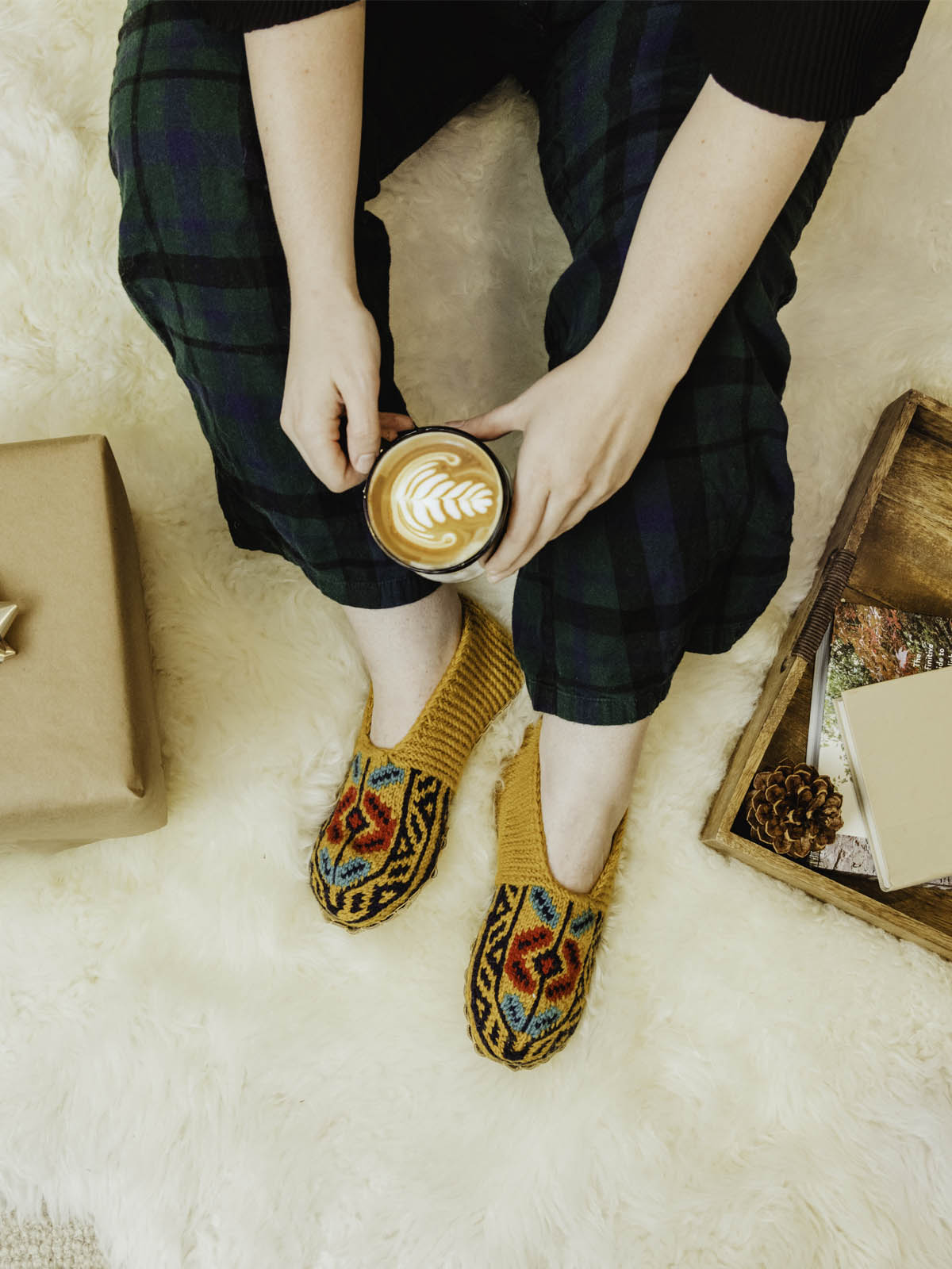 Yellow mustard slocks on a model wearing green plaid pans hold holding a  coffee mug