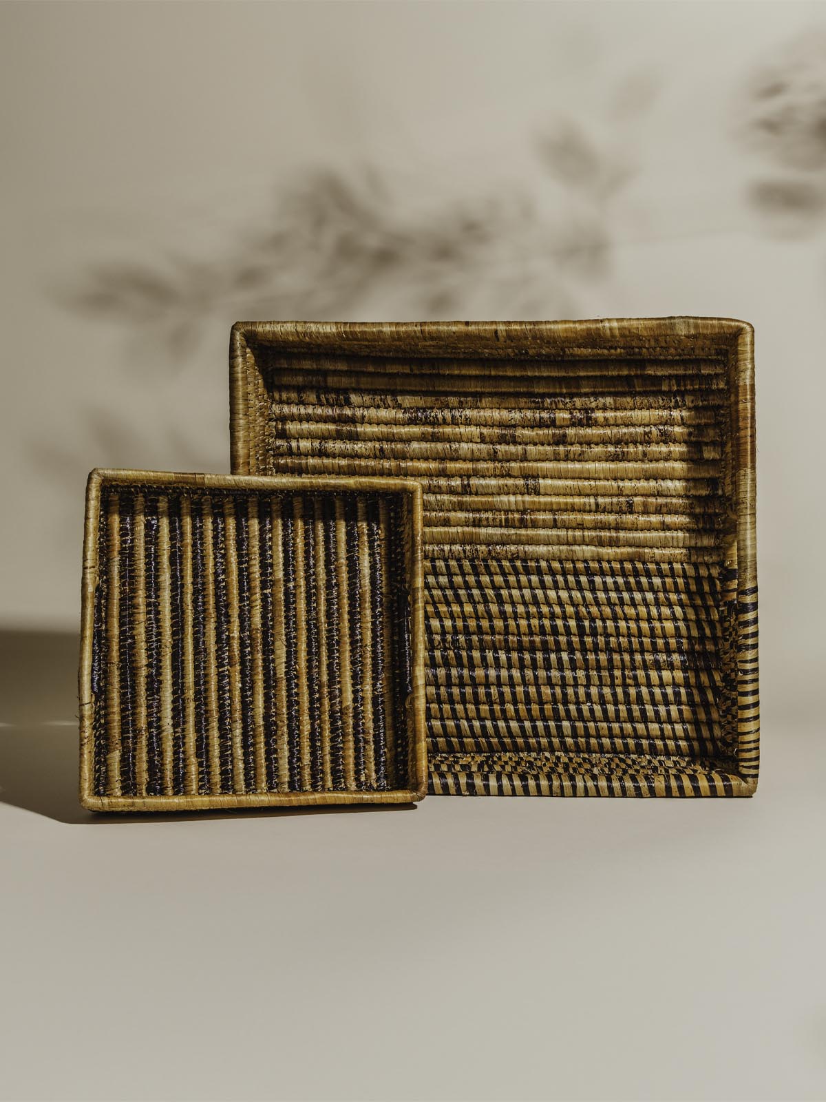 Two brown woven baskets in a square shape