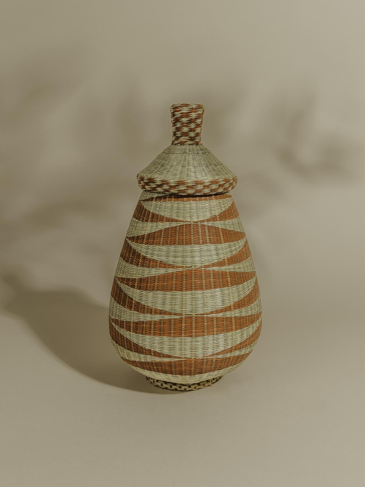 Tan and orange woven basket on a beige background
