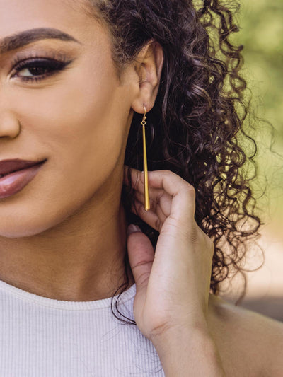 gold drop earrings on model