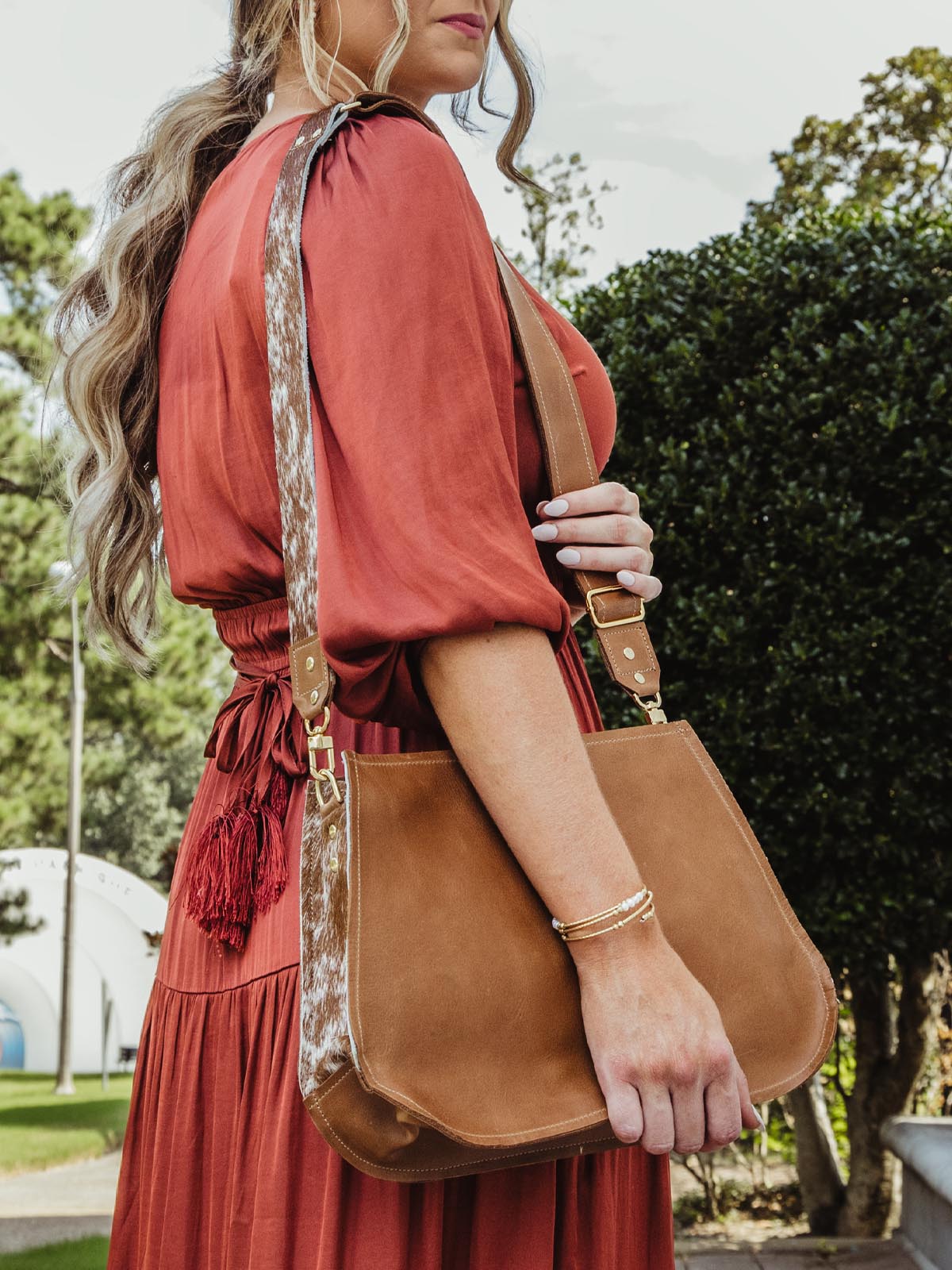 Brown leather bag worn by model in red dresss