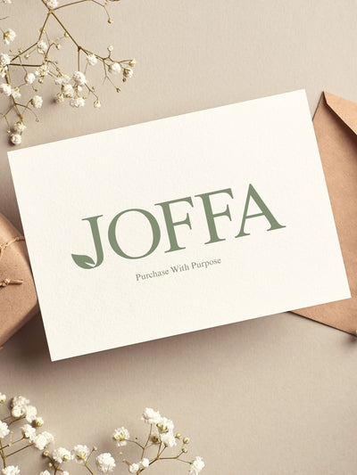 Joffa gift card on paper background with envelope and packaging. Accented with babies breathe flowers. 