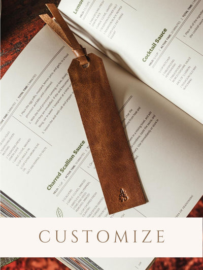 Customizable leather bookmark laying inside a book. 