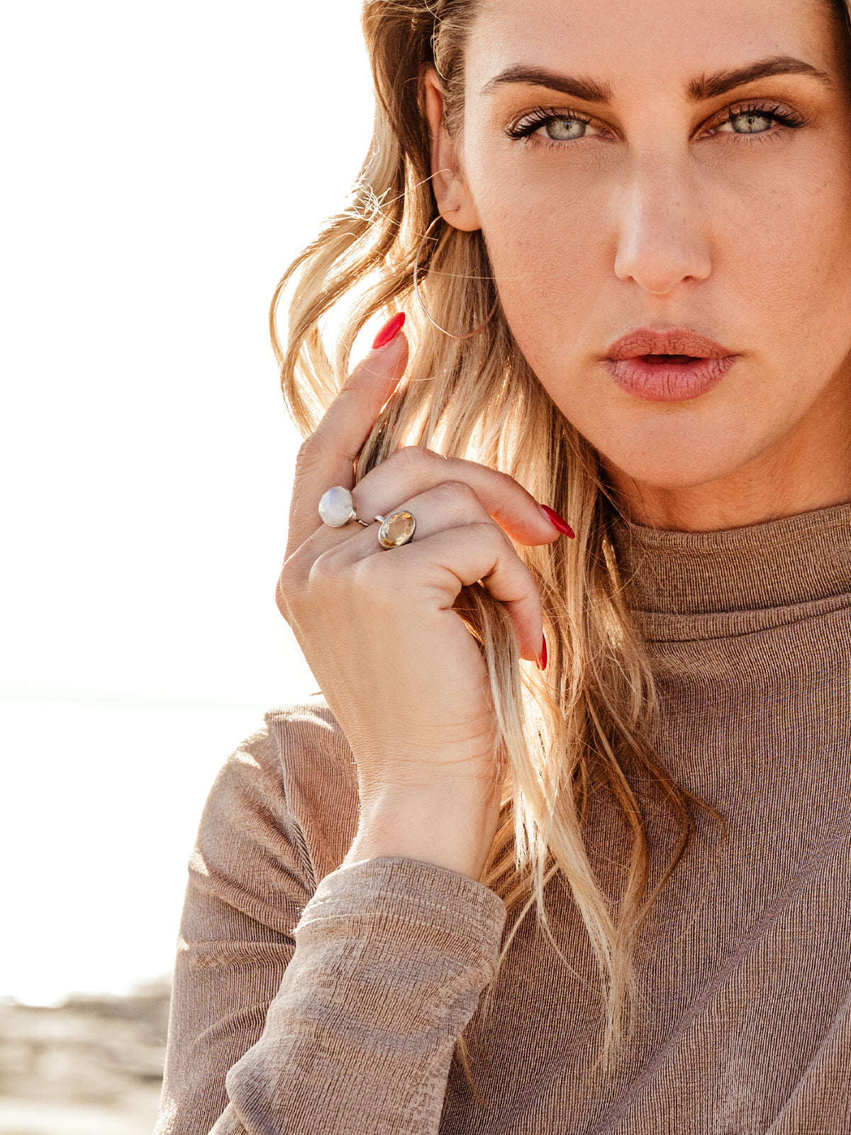 Female model wearing Oval Citrine Ring and white moonstone ring.