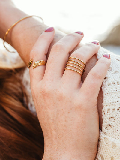 Golden Journey of Hope Ring on female model wearing other golden jewelry pieces. 