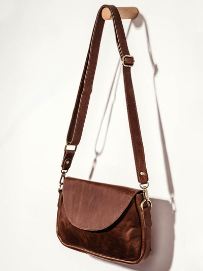 Joyn brown leather crossbody purse on white background.