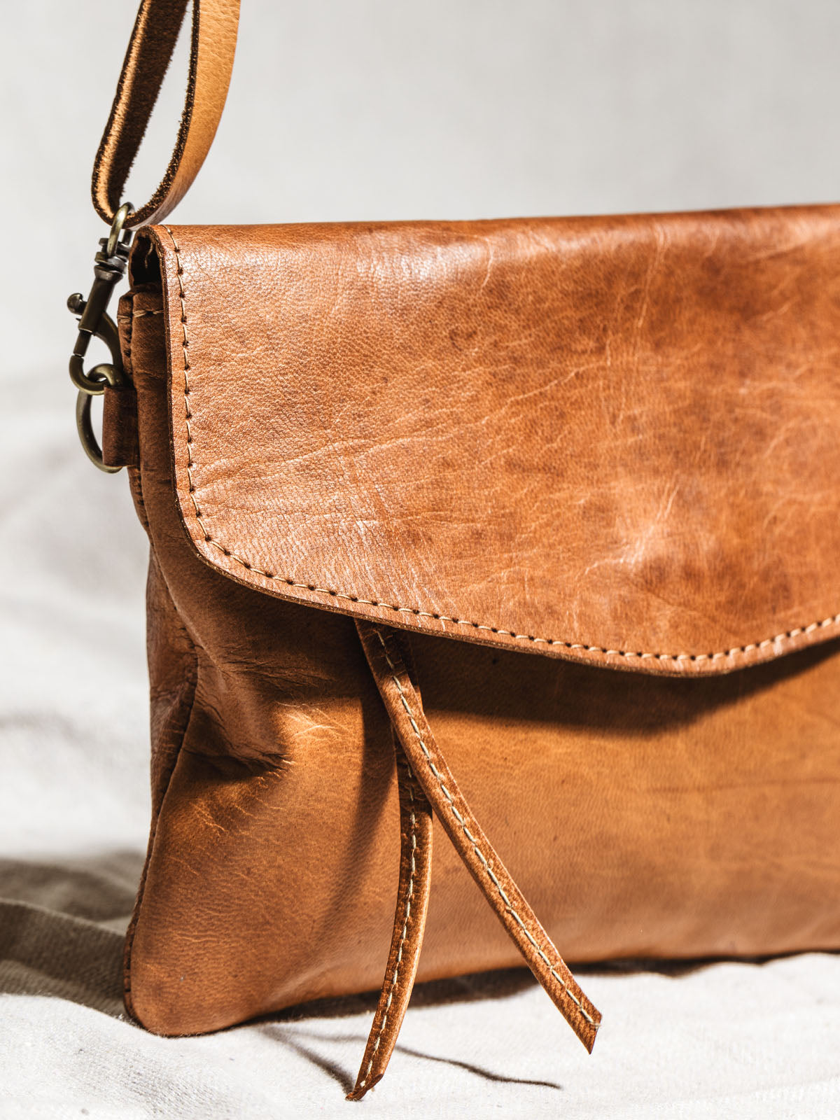 Close up of crossbody clutch leather and straps. 