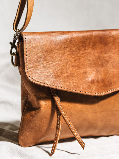 Close up of crossbody clutch leather and straps. 