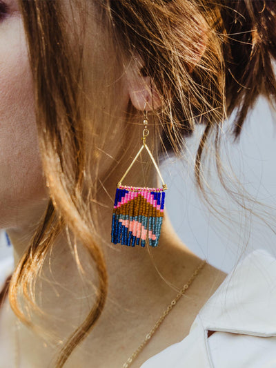 Close up of Neon Fringe earring on female model with loose hair.