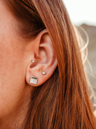 Female model with red hair wearing Kelly Mother of Pearl Stud Earrings.