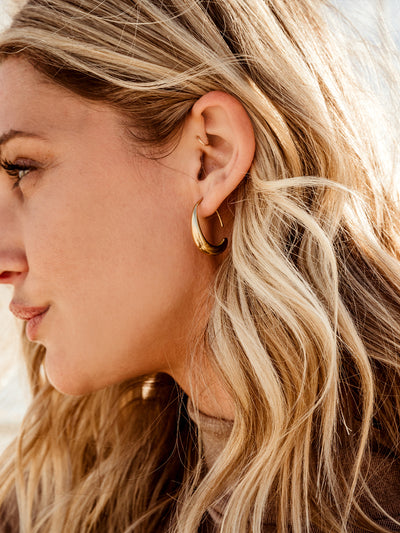 Side of female model's face wearing Crescent gold Moon Threader Drop Earring.