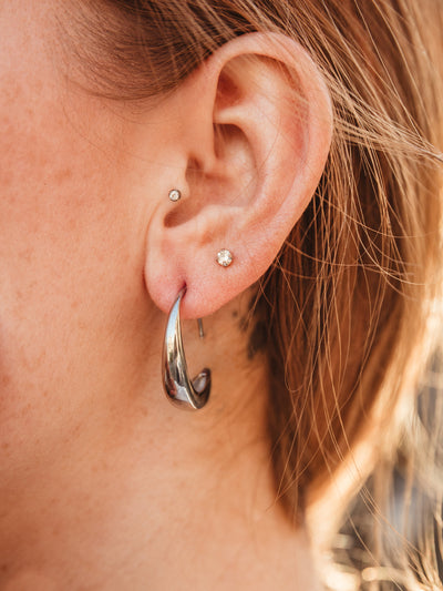 Close up of female ear wearing the silver Moon Threader Drop Earring.