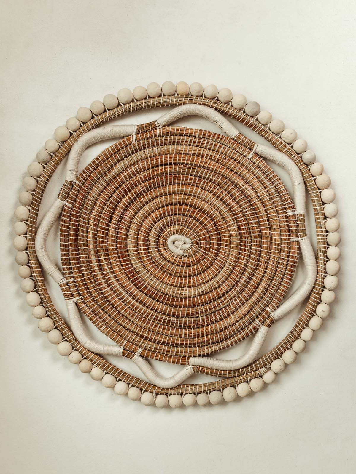 Woven beaded charger on a white table.