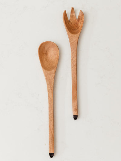 Set of wood serving spoons on white counter top.