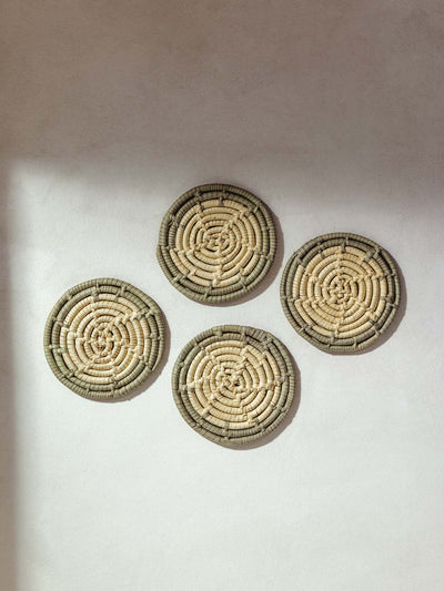 Four green coasters on a beige kitchen table