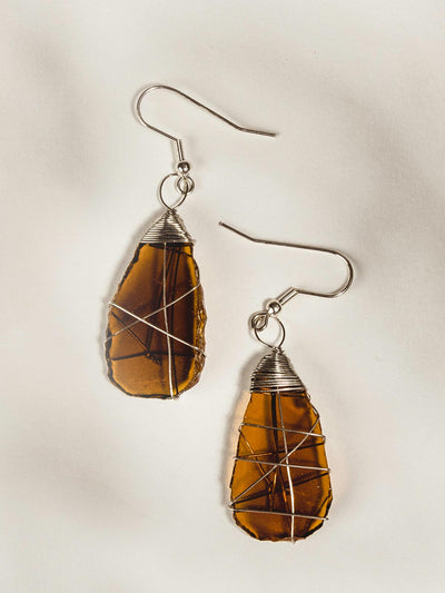 Amber glass earrings on white background. Amber glass is wrapped in silver wire.