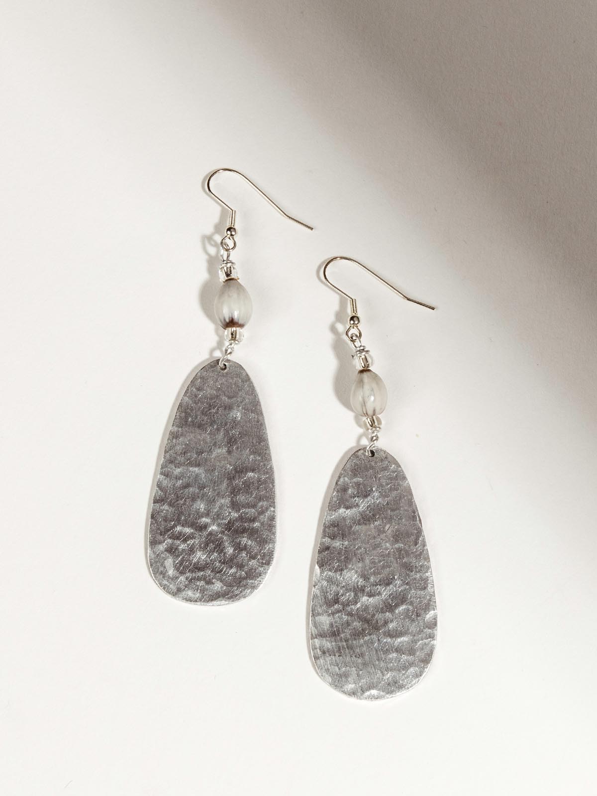 Aluminum earrings laid out over a white background