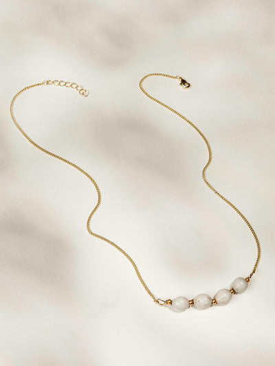 Gold necklace with four white beads