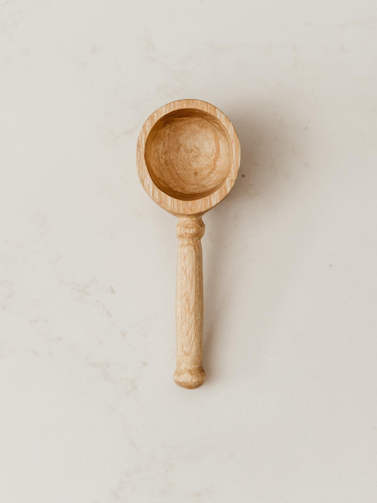 Coffee Scoop on white counter with slight detail seen on handle.