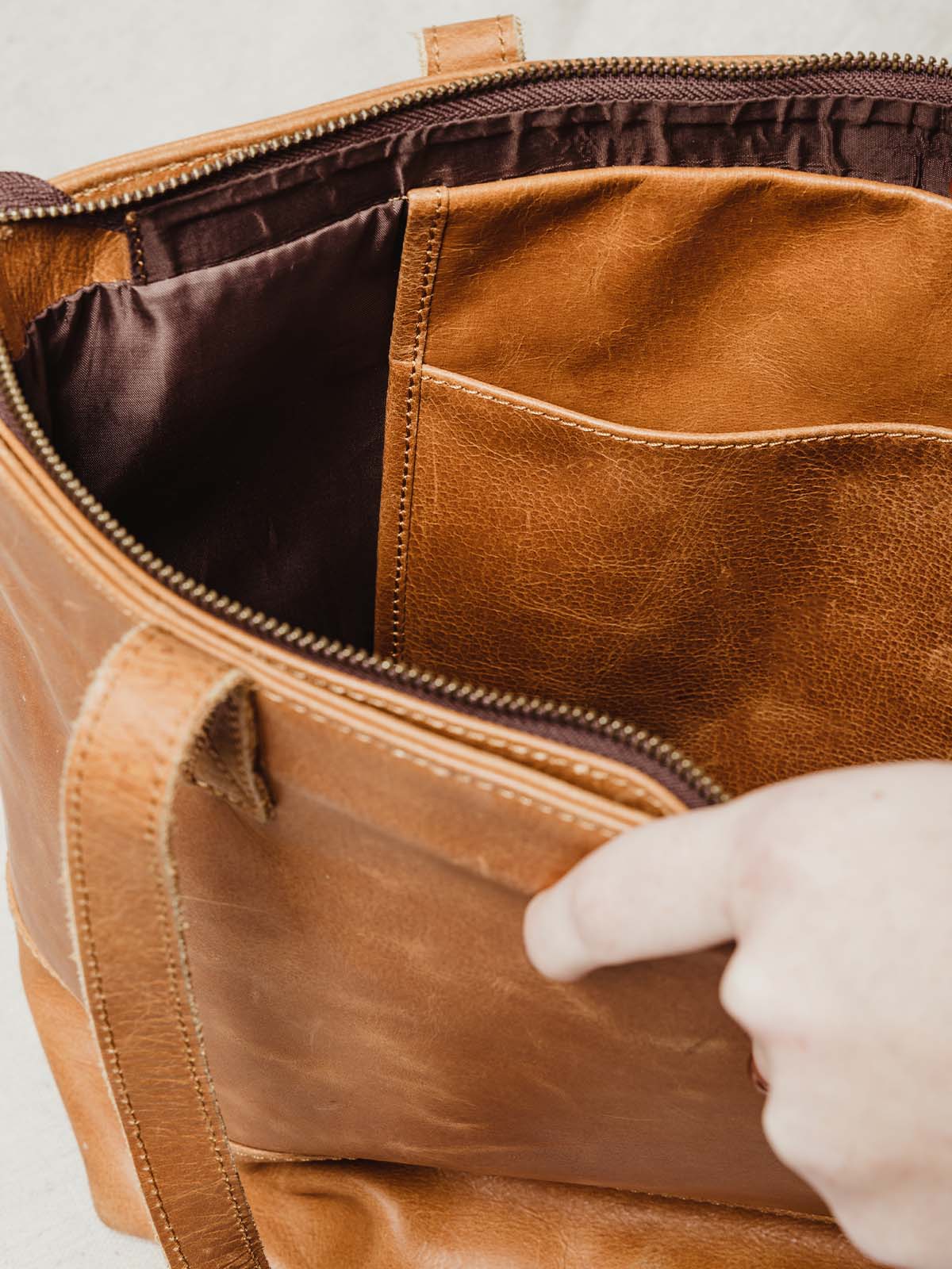 Interior close up on purses internal material. Handcrafted leather pouch for additional storage and quality dark brown lining. 