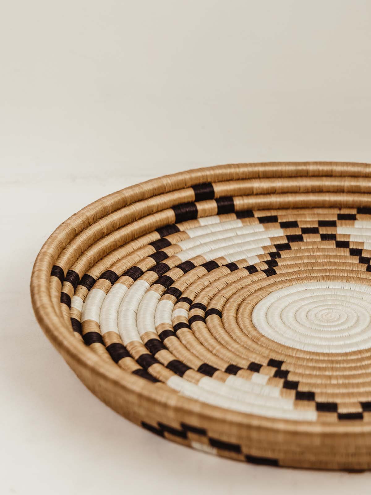 Large shallow woven bowl/tray with black and white detail pattern. 