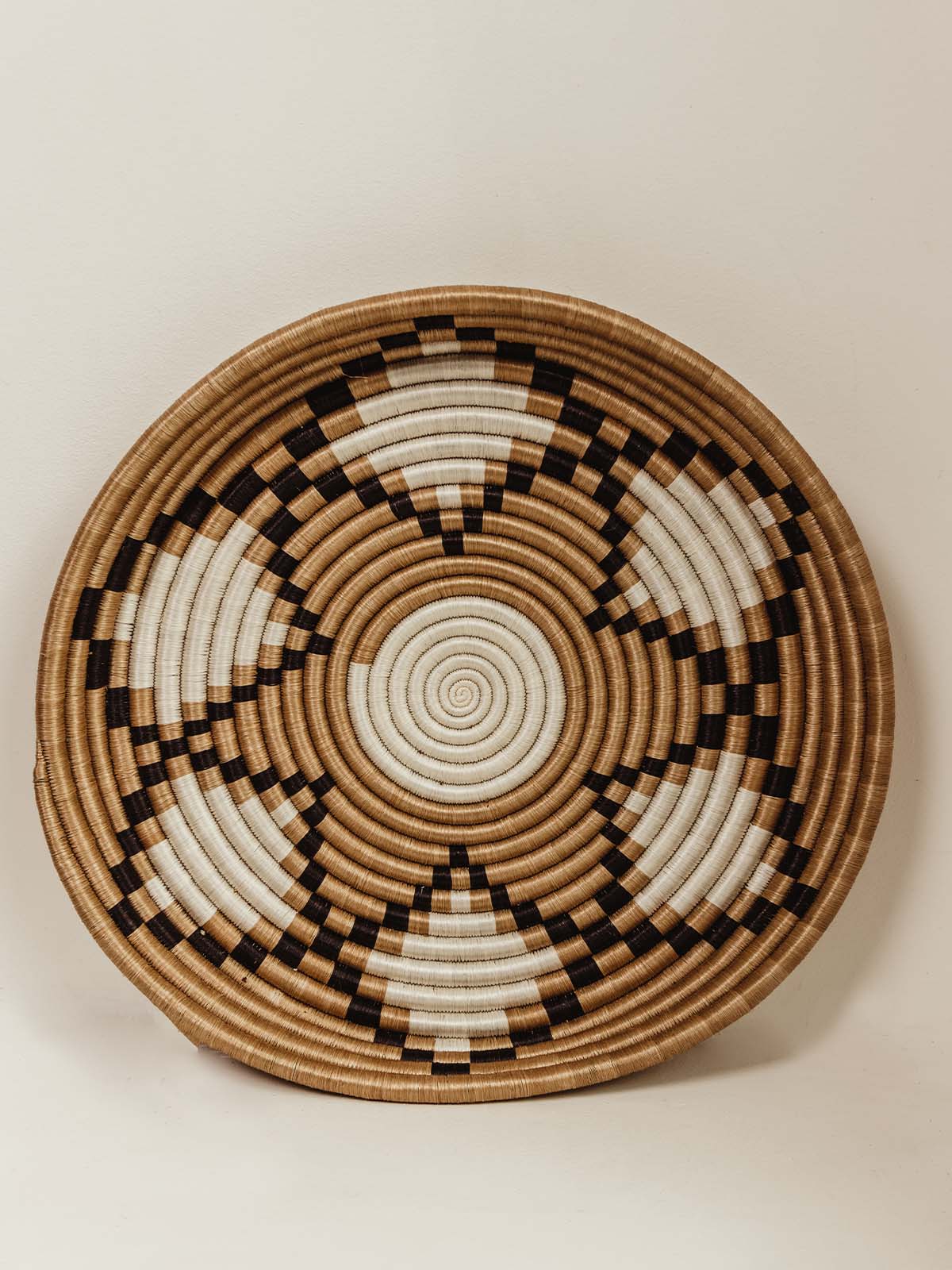 Large shallow woven bowl/tray with black and white detail pattern. Pattern is diamond shaped and floral.