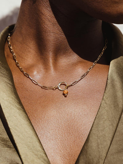 Gold Chain necklace on model with a featured burnt orange birthstone bead.