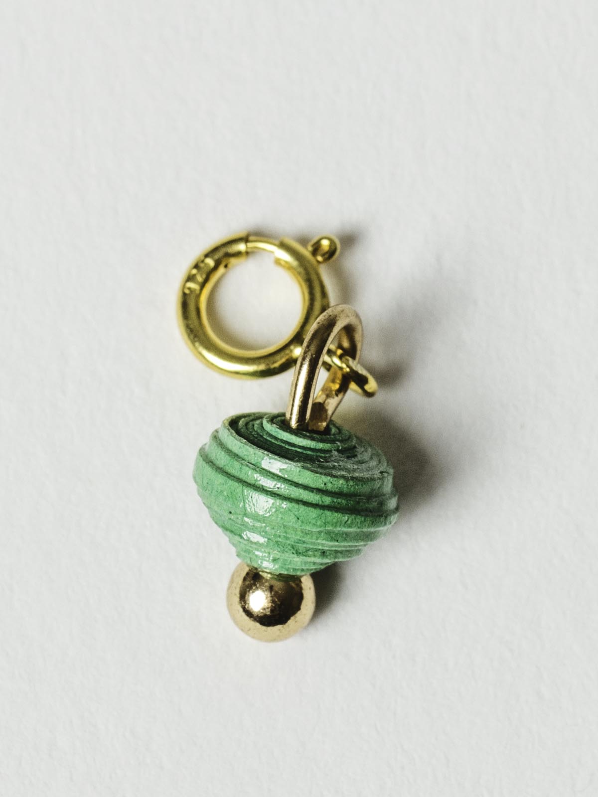 Medium green bead charm on gold clasp. 