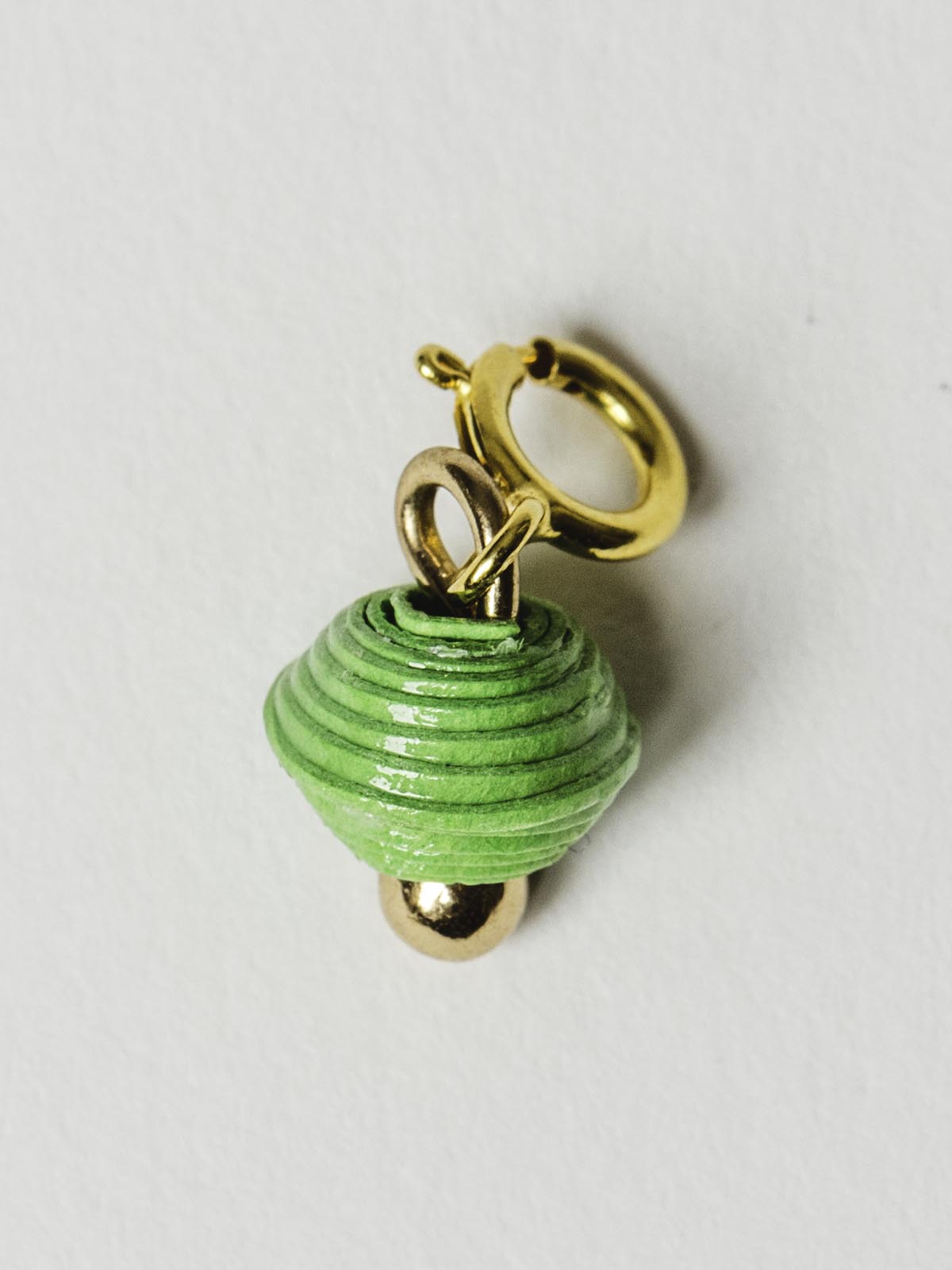 Bright green bead charm on gold clasp. 