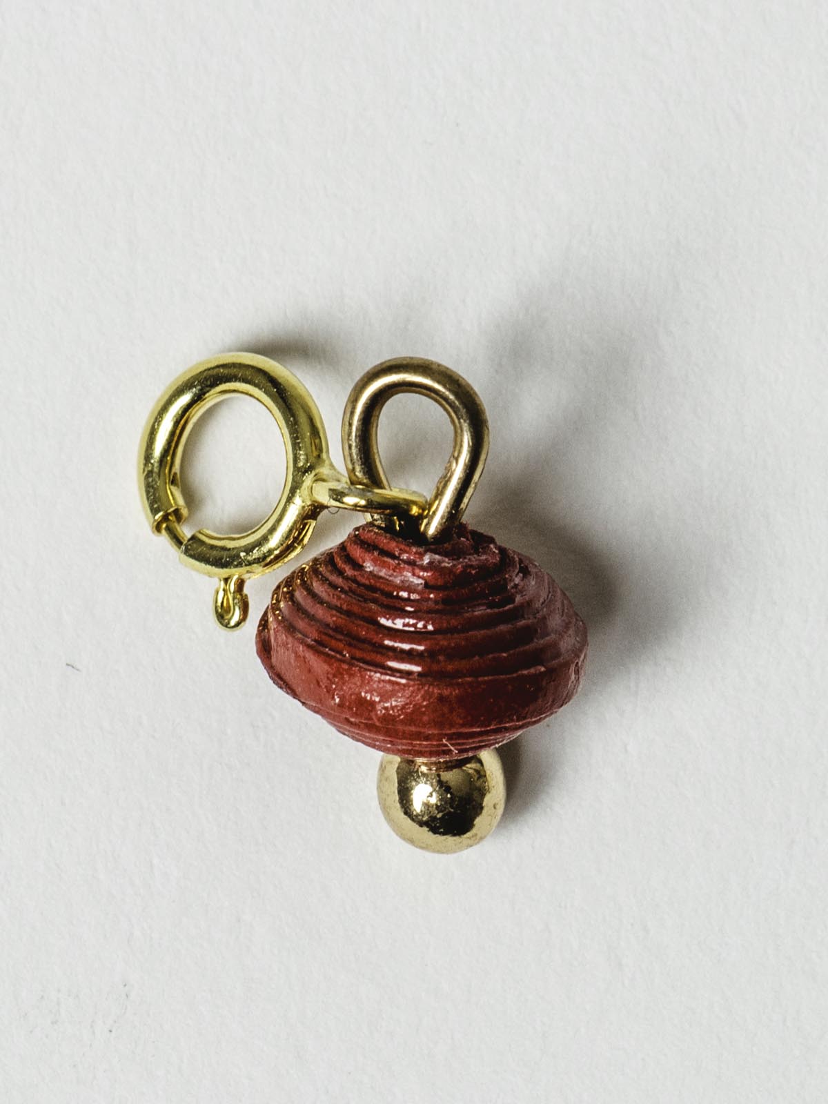 Ruby red bead charm on gold clasp. 