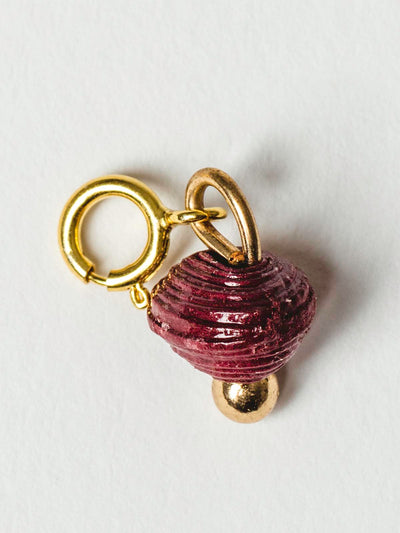 Dark red bead charm on gold clasp. 