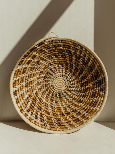Brown and tan woven basket on cream surface