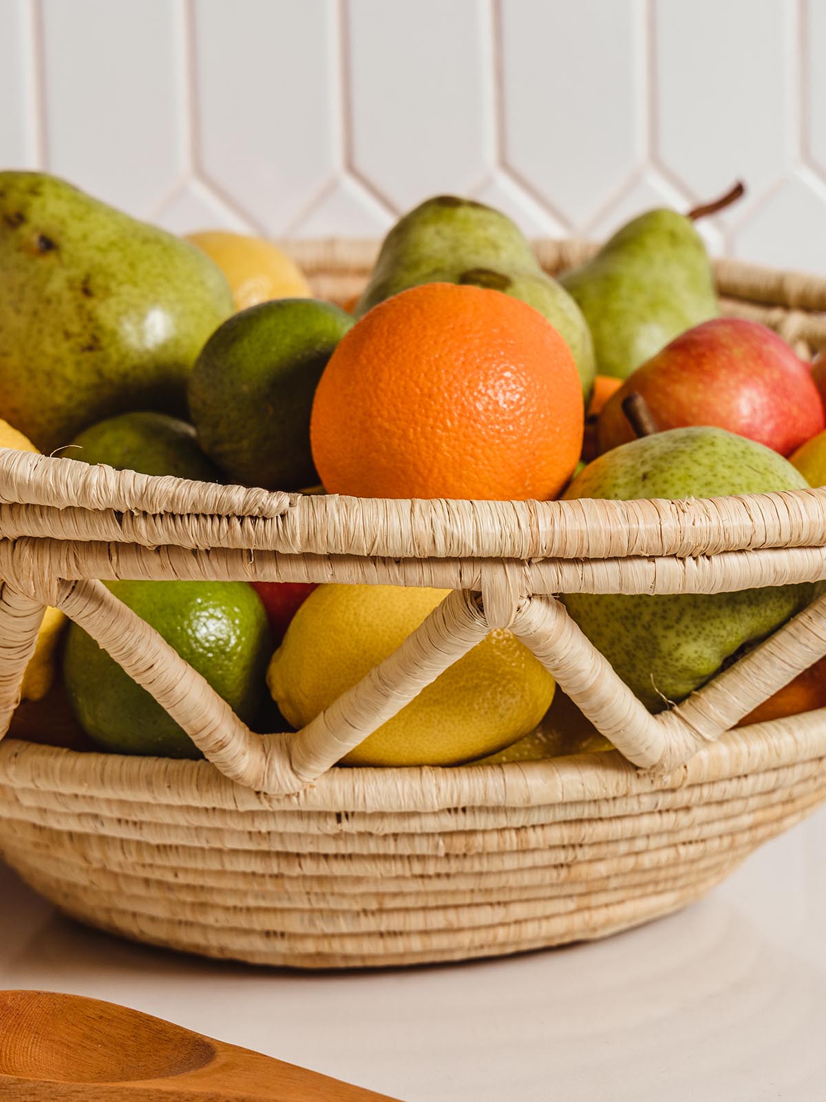 Detail of woven fruit basket full of a variety of fruits.