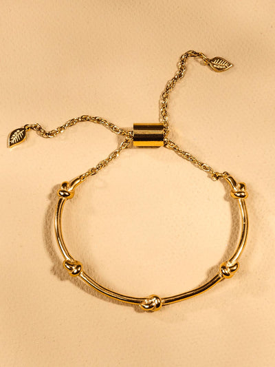 adjustable gold bracelet with knots and a gold chain