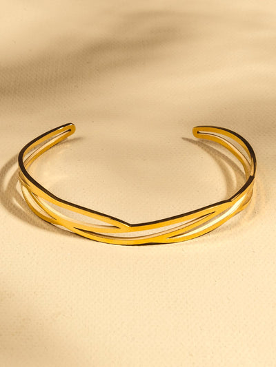 Golden cuff with abstract design on tan background