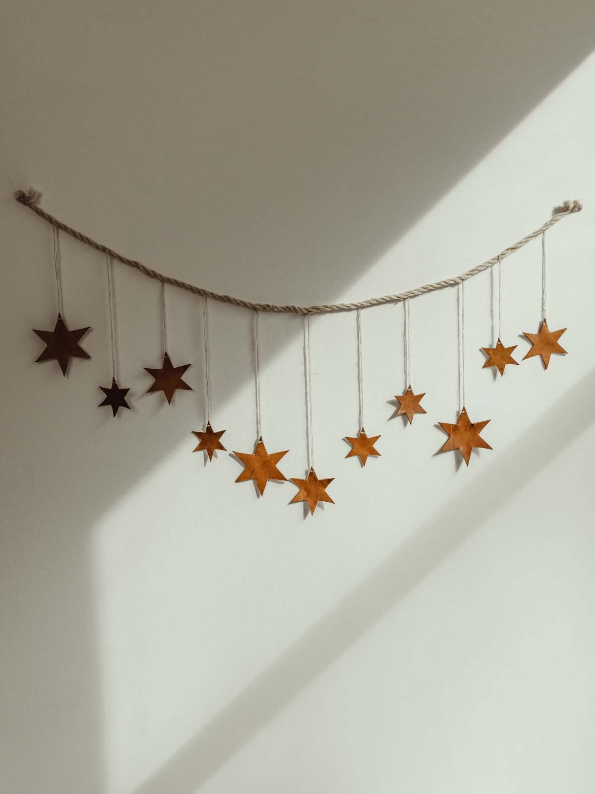 Star wall hanger with eleven leather stars string on cream string