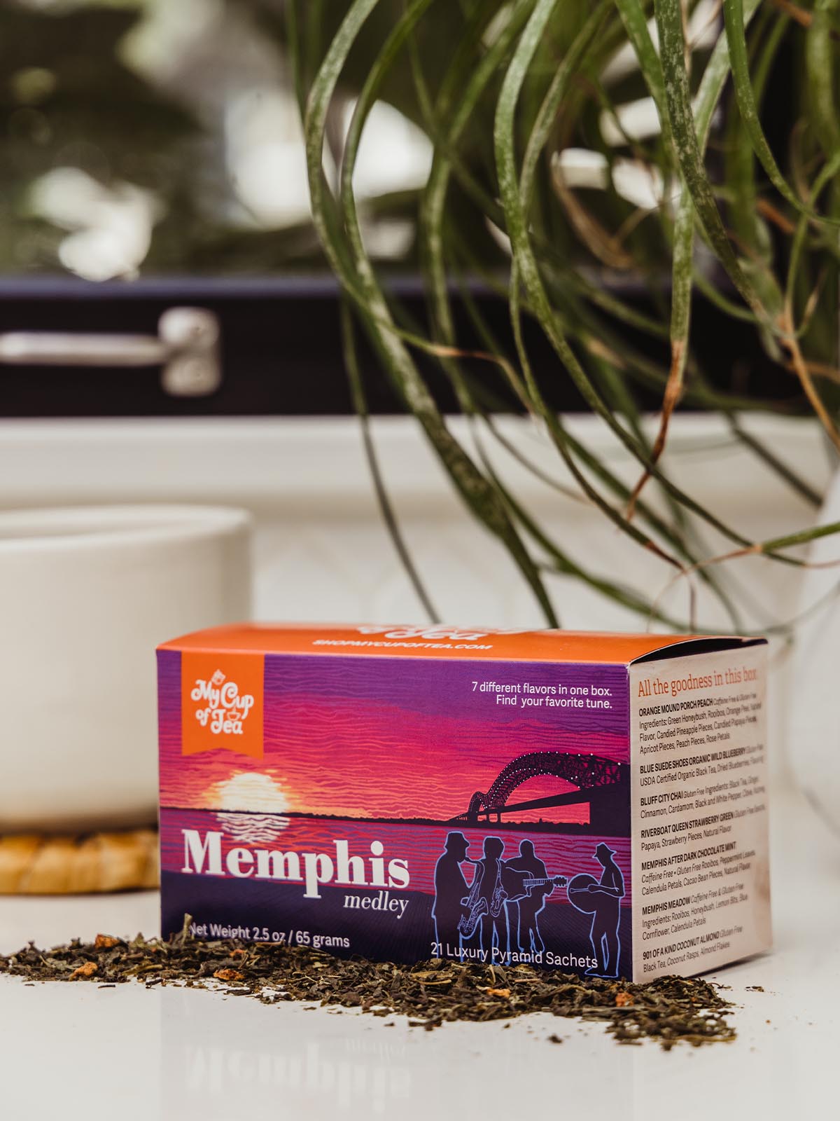 Memphis Medley Tea box on counter with coffee cup and greenery.