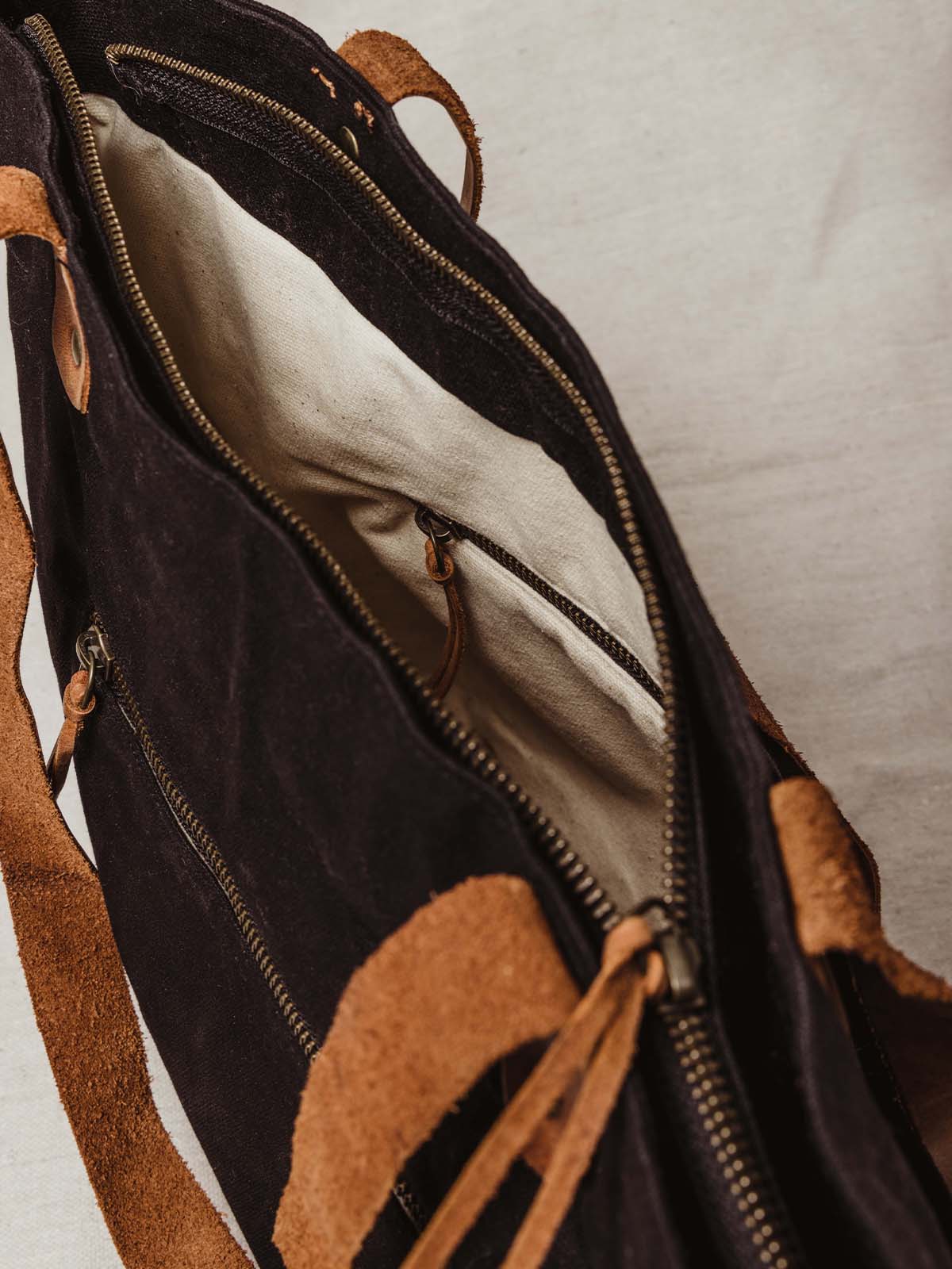 Closeup image of bags details. High quality leather and one internal and one external zipper for additional storage.