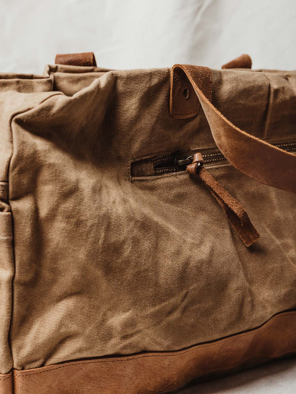 Tan weekender bag external zipper and leather details.