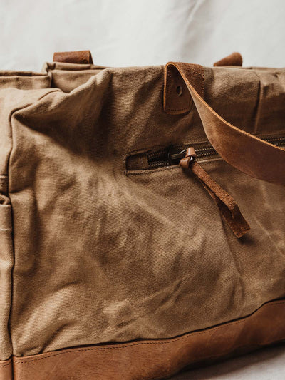Tan weekender bag external zipper and leather details.