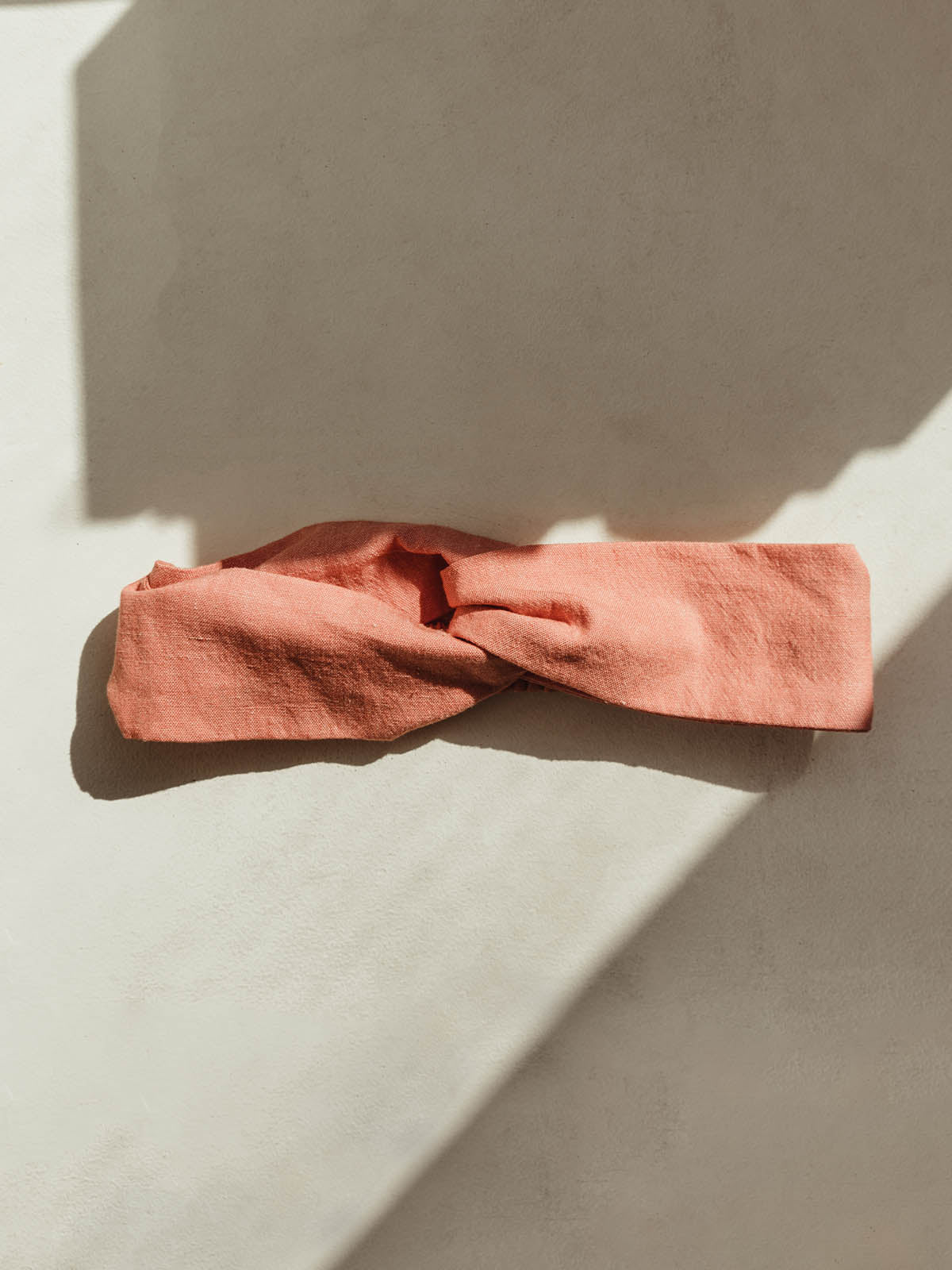coral cloth headband on white table